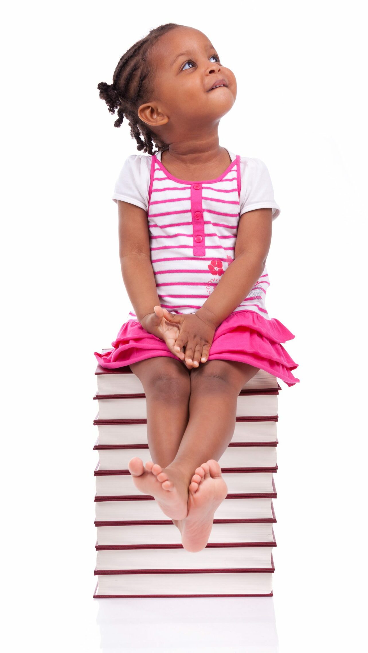 Girl in pink sitting on a stack of books